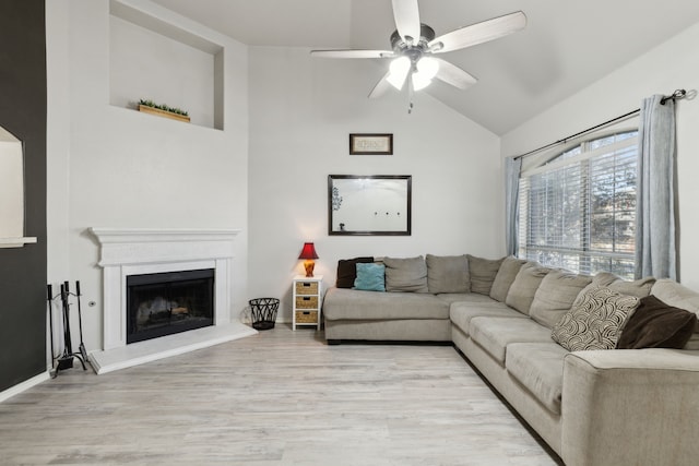 living room with ceiling fan, lofted ceiling, and light hardwood / wood-style flooring