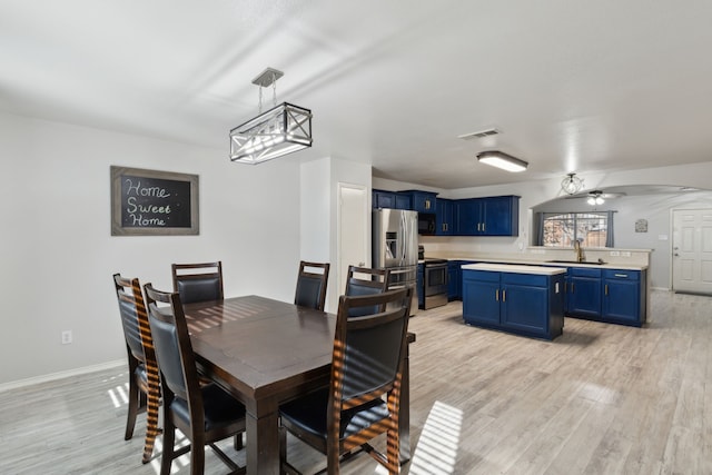 dining room with ceiling fan, light wood-type flooring, and sink