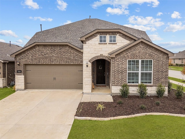 french country inspired facade with driveway, a shingled roof, a garage, and brick siding