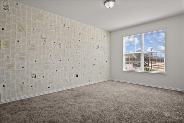 unfurnished room featuring carpet floors and baseboards