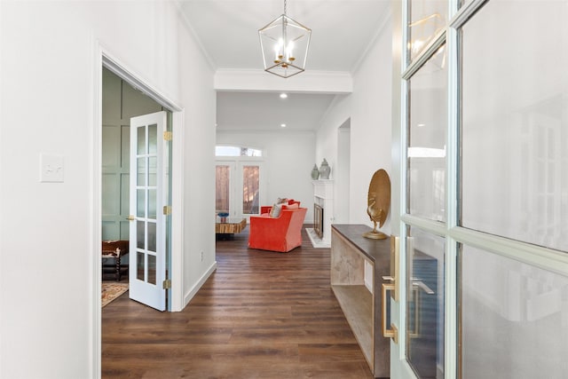 entrance foyer featuring an inviting chandelier, crown molding, dark wood-type flooring, and french doors