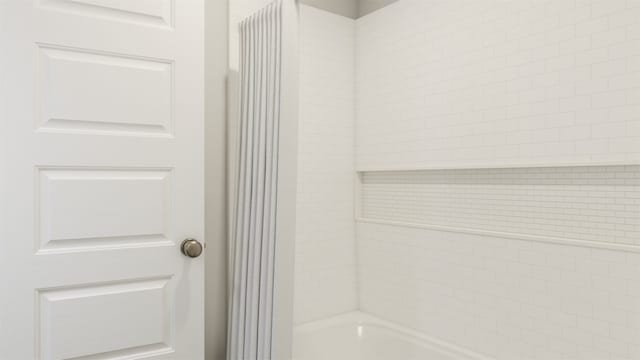 bathroom featuring tiled shower / bath