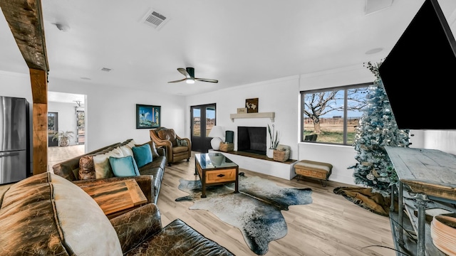 living room with light hardwood / wood-style floors and ceiling fan