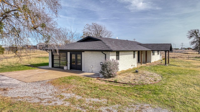 back of house featuring a yard and french doors