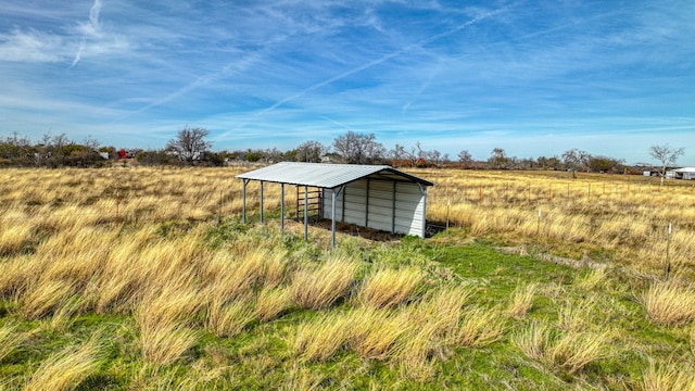 view of outbuilding with a rural view and a carport