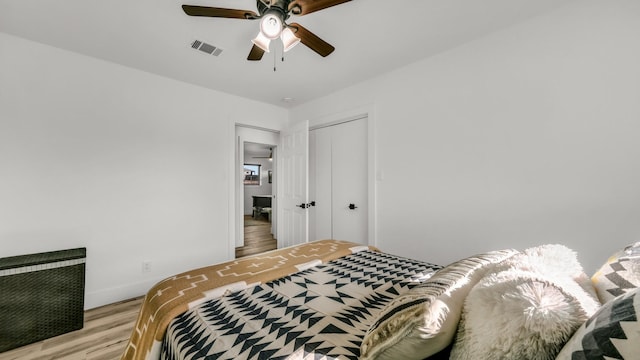 bedroom featuring ceiling fan, a closet, and light hardwood / wood-style flooring