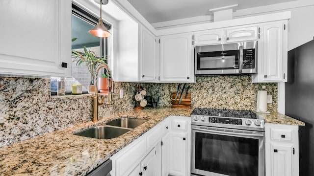 kitchen featuring white cabinetry, sink, backsplash, pendant lighting, and appliances with stainless steel finishes