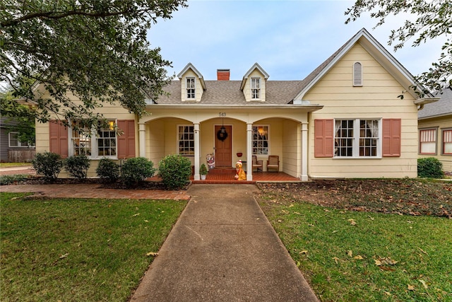 view of front of home with a front yard and a porch