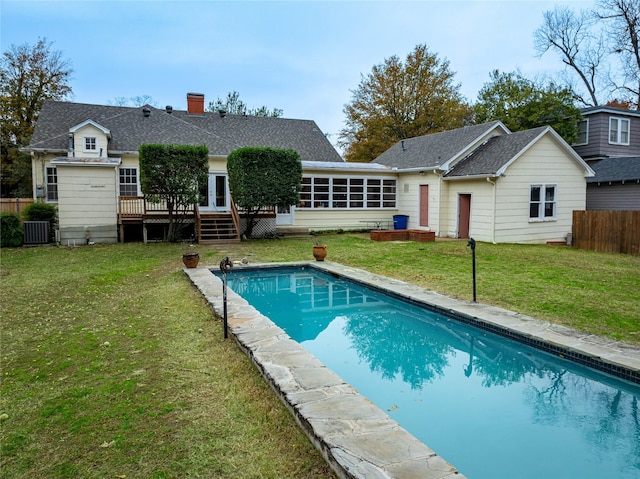 rear view of property with a pool side deck, a sunroom, a yard, and cooling unit