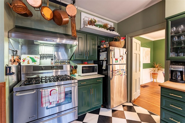 kitchen with ornamental molding, stainless steel appliances, and wall chimney exhaust hood