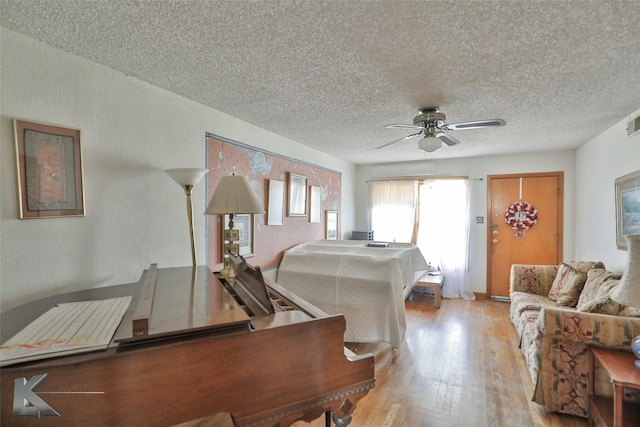 bedroom with ceiling fan, a textured ceiling, and light wood-type flooring