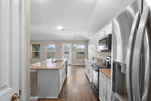 kitchen featuring dark wood-style floors, a center island with sink, a sink, stainless steel appliances, and white cabinetry