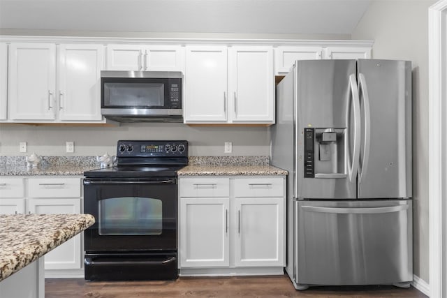 kitchen featuring light stone countertops, dark hardwood / wood-style flooring, white cabinets, and stainless steel appliances