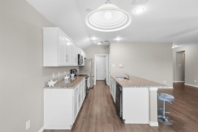 kitchen with stainless steel appliances, white cabinetry, a sink, and wood finished floors