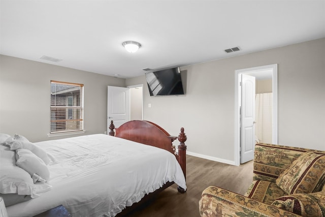 bedroom with visible vents, baseboards, and wood finished floors