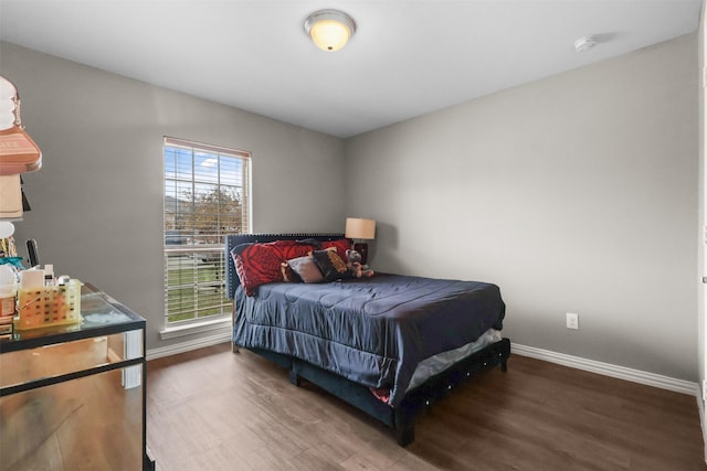 bedroom with baseboards and wood finished floors