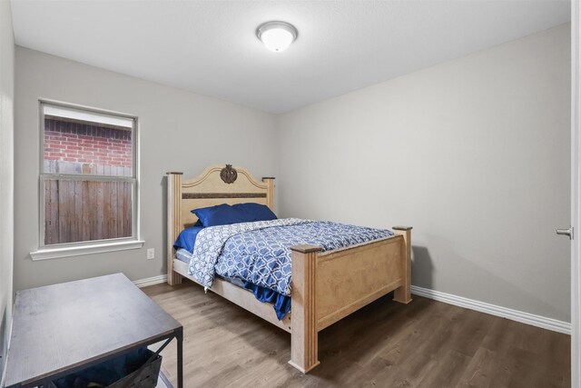 bedroom with baseboards and wood finished floors