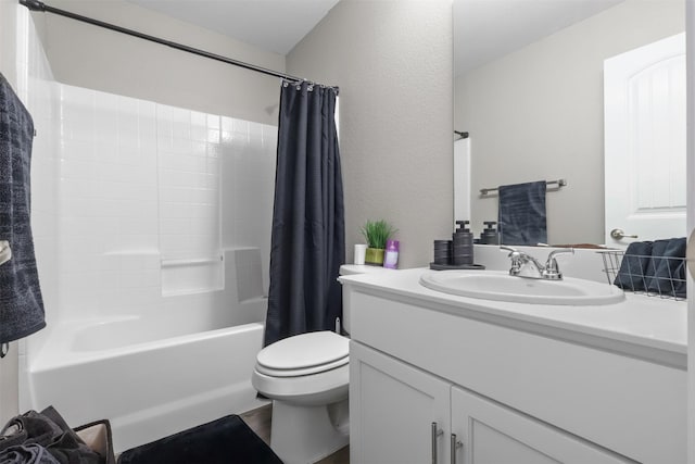 bathroom with vanity, toilet, a textured wall, and shower / bath combo with shower curtain