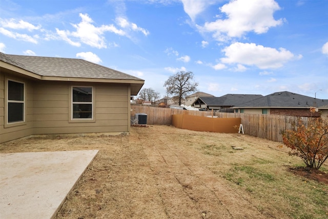 view of yard with central air condition unit and a fenced backyard