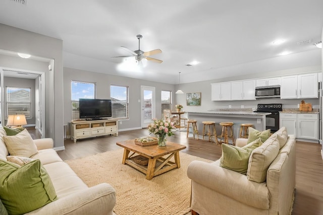 living room featuring light hardwood / wood-style floors and ceiling fan