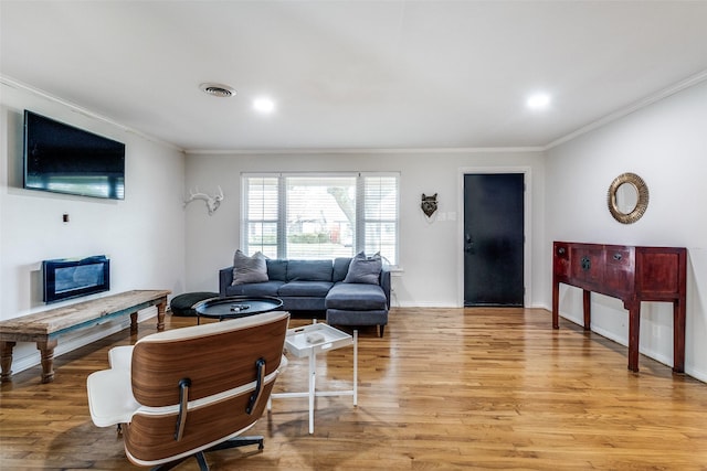 living room featuring crown molding and light wood-type flooring