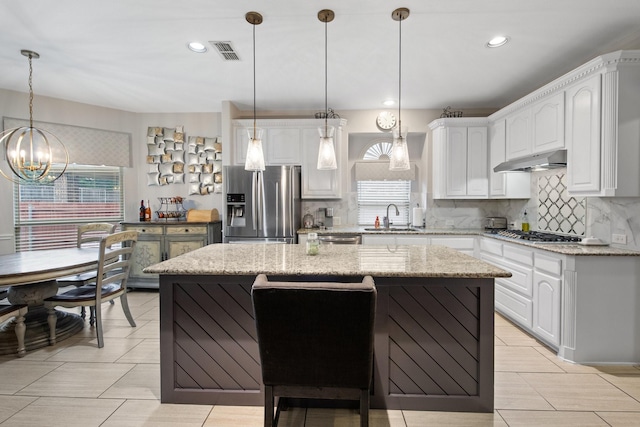 kitchen featuring stainless steel appliances, a kitchen island, and white cabinets