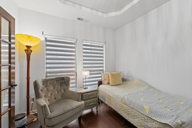 bedroom featuring dark hardwood / wood-style flooring and a tray ceiling