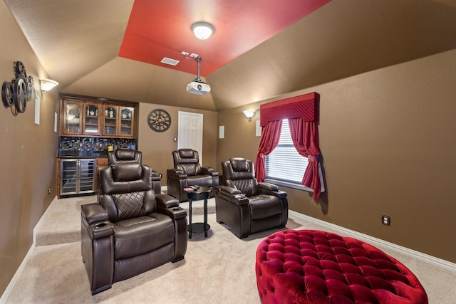 home theater room featuring wine cooler, carpet floors, bar area, and vaulted ceiling