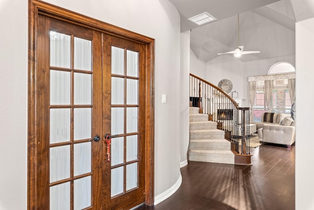 foyer entrance featuring vaulted ceiling, dark hardwood / wood-style floors, ceiling fan, and french doors