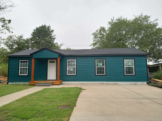 view of front facade featuring concrete driveway and a front yard