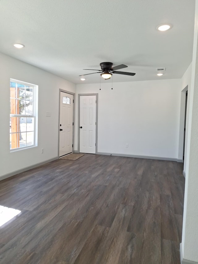 unfurnished living room with visible vents, ceiling fan, baseboards, recessed lighting, and dark wood-style floors