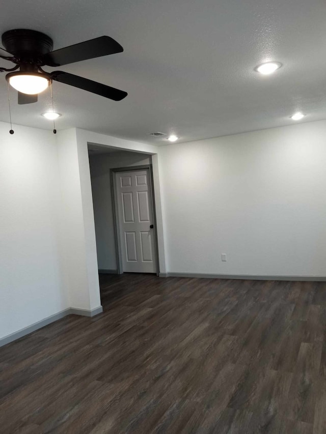 empty room with dark hardwood / wood-style floors and ceiling fan