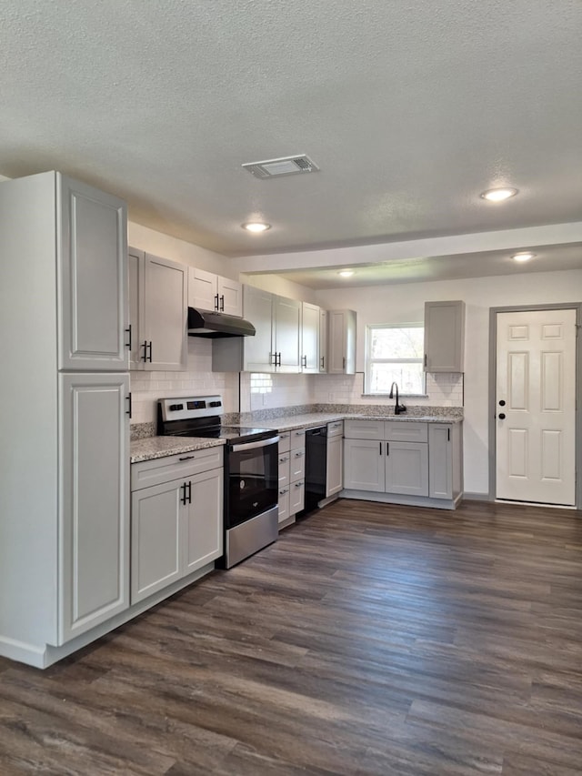 kitchen featuring visible vents, under cabinet range hood, dishwasher, stainless steel range with electric cooktop, and a sink