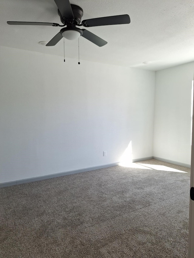 empty room featuring carpet flooring, baseboards, and a textured ceiling