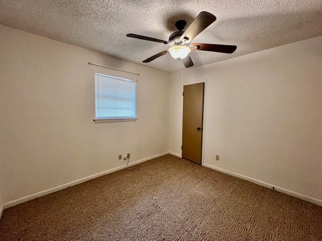 carpeted empty room featuring ceiling fan and a textured ceiling