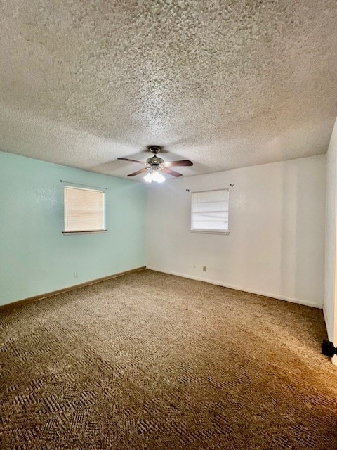 carpeted spare room featuring ceiling fan, a textured ceiling, and a wealth of natural light