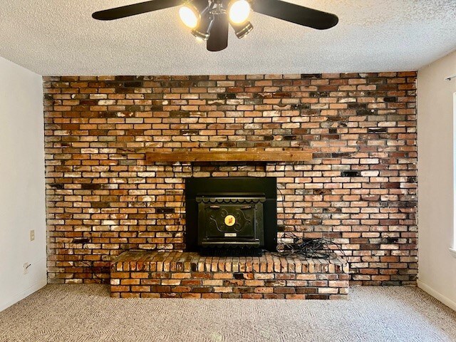 room details featuring ceiling fan, carpet floors, and a textured ceiling