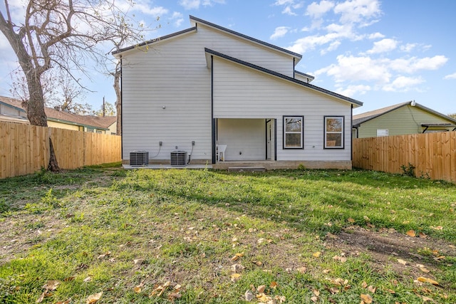 rear view of house featuring a yard and cooling unit