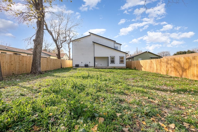 back of house featuring central AC and a lawn