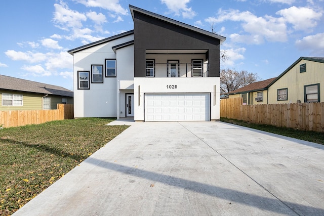 view of front of property featuring a balcony, a front yard, and a garage