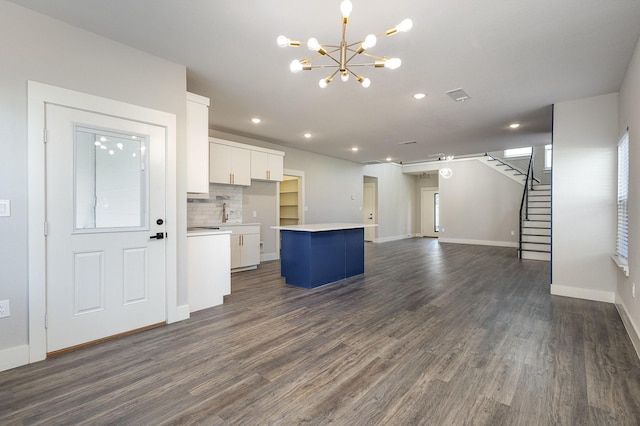 kitchen with dark hardwood / wood-style flooring, white cabinetry, a kitchen island, and hanging light fixtures