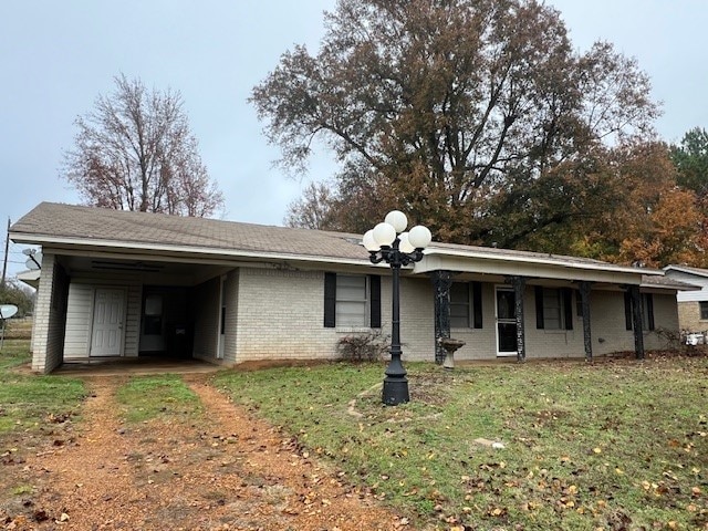 view of front facade featuring a front yard and a carport