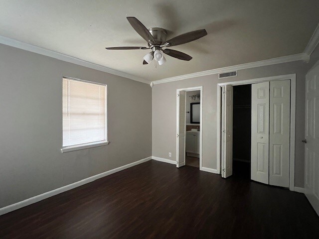 unfurnished bedroom with ceiling fan, dark hardwood / wood-style flooring, and crown molding