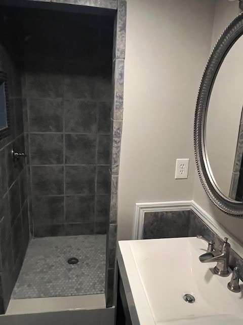 bathroom featuring tiled shower and sink