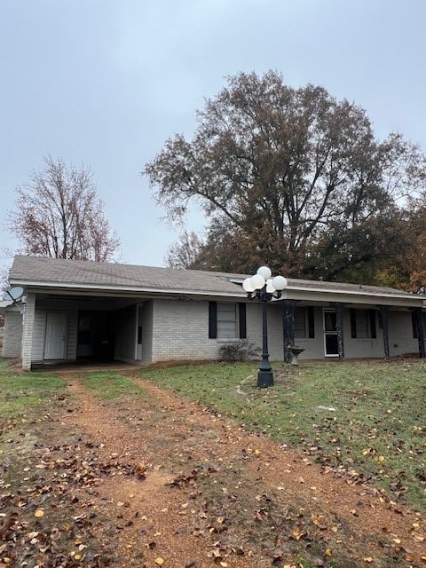 view of front facade with a carport and a front yard