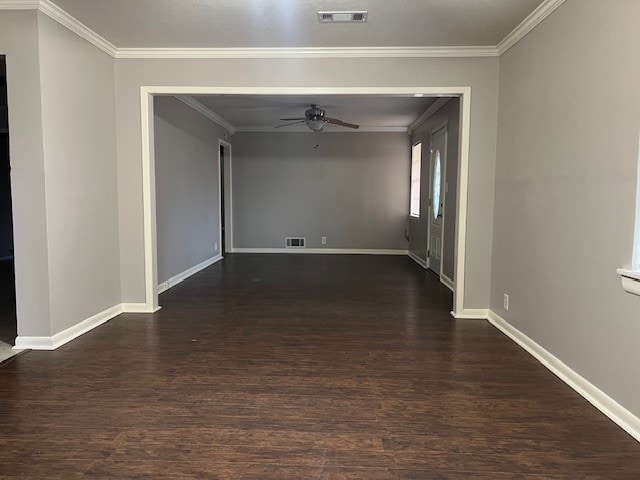 empty room with ceiling fan, dark wood-type flooring, and ornamental molding