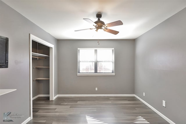 unfurnished bedroom featuring ceiling fan, dark hardwood / wood-style floors, and a closet