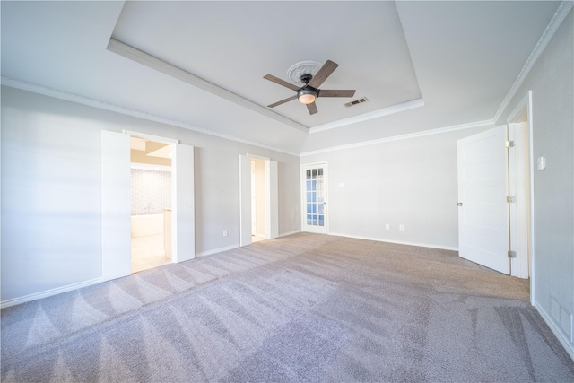 carpeted empty room with a raised ceiling, crown molding, and ceiling fan