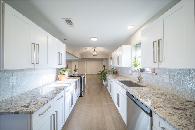 kitchen with white cabinetry, sink, stainless steel appliances, light stone counters, and light hardwood / wood-style floors