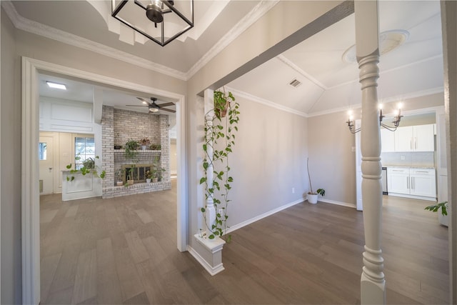 hall featuring crown molding, dark hardwood / wood-style flooring, a chandelier, and vaulted ceiling